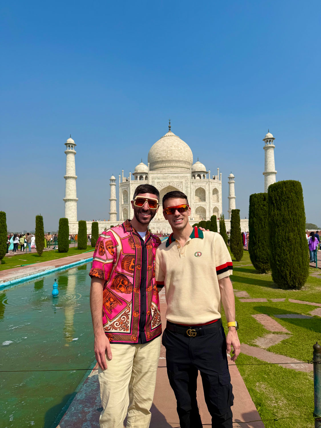 Christopher and Jesse from Borderless Bros Club pose in front of the Taj Mahal, embracing India's iconic architecture during their global travel adventures.